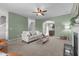 Comfortable living room with green walls, neutral furniture, ceiling fan, and open access to other areas at 576 Prairie Ln, Lillington, NC 27546
