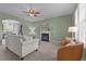 Cozy living room with a fireplace, neutral furniture, ceiling fan, and an archway to the kitchen at 576 Prairie Ln, Lillington, NC 27546