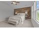 Spacious primary bedroom with a wood accent wall, plush carpet, and natural light at 576 Prairie Ln, Lillington, NC 27546
