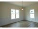 Bright dining room with two windows, chair rail, luxury vinyl tile flooring, and contemporary light fixture at 614 Tart Town Rd, Dunn, NC 28334