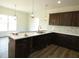 This kitchen features dark wood cabinets, an island with a sink, and white counters with stylish pendant lighting at 614 Tart Town Rd, Dunn, NC 28334