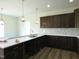 Modern kitchen features dark wood cabinets, white countertops, stylish pendant lighting, and wood-look floors at 614 Tart Town Rd, Dunn, NC 28334