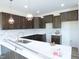 Spacious kitchen features dark cabinets, modern light fixtures, white counter tops, and tile backsplash at 614 Tart Town Rd, Dunn, NC 28334