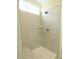 This modern shower boasts updated fixtures, neutral tiling, a built in seat, and glass shelves for ample storage at 614 Tart Town Rd, Dunn, NC 28334