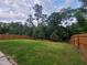 Expansive grassy backyard with a privacy fence and mature trees at 617 Hiddenbrook Dr, Durham, NC 27703