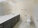 Well-lit bathroom featuring a double vanity, large mirror, and a toilet, with tiled flooring at 617 Hiddenbrook Dr, Durham, NC 27703