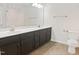 Bathroom with a dual sink vanity with dark wood cabinets, a large mirror, and a toilet at 617 Hiddenbrook Dr, Durham, NC 27703