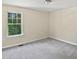 An empty bedroom features a cozy carpet and natural light from the window at 617 Hiddenbrook Dr, Durham, NC 27703