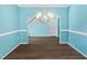 Formal dining room with wood floors, blue walls, decorative trim, and a modern chandelier at 617 Hiddenbrook Dr, Durham, NC 27703
