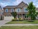 Two-story home featuring a manicured lawn, attached garage, and charming front porch at 617 Hiddenbrook Dr, Durham, NC 27703