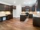Spacious kitchen with wood floors, dark cabinets, granite countertops, and modern appliances at 617 Hiddenbrook Dr, Durham, NC 27703