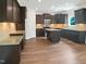 Spacious kitchen with wood floors, dark cabinets, granite countertops, and stainless appliances at 617 Hiddenbrook Dr, Durham, NC 27703