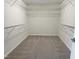 An organized walk-in closet with neutral carpet, white walls and metal shelving at 617 Hiddenbrook Dr, Durham, NC 27703