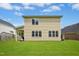 Spacious backyard features a lawn, house with neutral siding, many windows and covered patio area at 634 Cotton Brook Dr, Fuquay Varina, NC 27526
