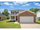 Charming two-story home with a brick and vinyl facade, a well-manicured lawn, and an attached two-car garage at 634 Cotton Brook Dr, Fuquay Varina, NC 27526