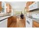 Open-concept kitchen with stainless appliances, wood cabinets, hardwood floors, and a view into the dining area at 634 Cotton Brook Dr, Fuquay Varina, NC 27526