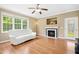 Bright living room with a fireplace, ceiling fan, large windows, hardwood floors, and neutral paint at 634 Cotton Brook Dr, Fuquay Varina, NC 27526