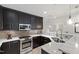 Well-lit kitchen featuring stainless steel appliances, marble countertops, and sleek cabinets at 710 Independence Pl # 103, Raleigh, NC 27603