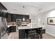 Spacious kitchen with black cabinets, bar seating, and stainless steel appliances at 710 Independence Pl # 103, Raleigh, NC 27603