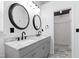 Bathroom featuring double sinks, marble countertops, framed mirrors, vanity lighting, and marble flooring at 717 Samuel Cary Dr, Cary, NC 27511