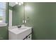 Powder room featuring a modern vanity, stylish mirror, and olive-green walls at 717 Samuel Cary Dr, Cary, NC 27511
