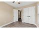 Neutral bedroom features wood-look floors, ceiling fan, closet, and connecting door at 717 Samuel Cary Dr, Cary, NC 27511