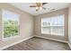 Bedroom featuring luxury vinyl floors, two bright windows, neutral walls, and ceiling fan at 717 Samuel Cary Dr, Cary, NC 27511