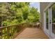 View of the wood deck with a door leading inside and surrounded by a lush green landscape at 717 Samuel Cary Dr, Cary, NC 27511
