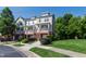 Townhome complex showcasing landscaped grounds, sidewalk, and covered front porches at 717 Samuel Cary Dr, Cary, NC 27511