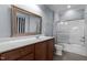 Bathroom featuring a single sink vanity, mirror, tiled flooring and shower/tub combo with glass door at 735 Portstewart Dr, Cary, NC 27519