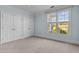 Bedroom with neutral carpet, light blue walls, large window and closet at 735 Portstewart Dr, Cary, NC 27519