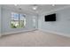A bright bedroom with a large window, balcony door, neutral carpet and blue walls at 735 Portstewart Dr, Cary, NC 27519