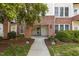A ground-level entrance to a condo building featuring brick accents and manicured landscaping at 735 Portstewart Dr, Cary, NC 27519