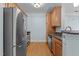 Galley kitchen with stainless steel appliances, granite countertops, and light wood cabinetry at 735 Portstewart Dr, Cary, NC 27519