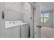 Bright laundry room with washer, dryer, overhead shelving, and an open doorway to the next room at 735 Portstewart Dr, Cary, NC 27519