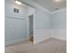 A spare living space featuring neutral carpet and wainscoting detail on the blue walls at 735 Portstewart Dr, Cary, NC 27519