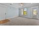 A bright room featuring neutral carpet, blue walls, and a door leading to the exterior at 735 Portstewart Dr, Cary, NC 27519
