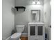 Powder room featuring a toilet, single sink vanity, mirror, and wood-look flooring at 735 Portstewart Dr, Cary, NC 27519