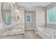 Bathroom featuring a double sink vanity, an oval mirror, a bathtub, and a walk-in shower at 736 Varina Ln, Fuquay Varina, NC 27526