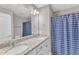 Bathroom featuring double sinks with granite countertops, a large mirror, and a shower with a patterned curtain at 736 Varina Ln, Fuquay Varina, NC 27526