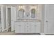 Double sink vanity with granite countertop, framed mirrors, and white cabinetry at 736 Varina Ln, Fuquay Varina, NC 27526