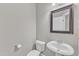 Well-lit powder room featuring a toilet, a pedestal sink, a mirror, and neutral colors at 736 Varina Ln, Fuquay Varina, NC 27526