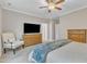 Spacious bedroom with comfortable chair, ceiling fan, and a large dresser with mounted TV at 736 Varina Ln, Fuquay Varina, NC 27526