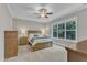 Bright bedroom with a ceiling fan, a large window, and wooden furniture at 736 Varina Ln, Fuquay Varina, NC 27526