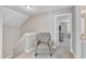Hallway with a comfortable chair leading to a bedroom with neutral paint colors and carpet flooring at 736 Varina Ln, Fuquay Varina, NC 27526
