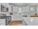 Kitchen features stainless steel appliances, white cabinets, quartz countertops, and stylish tile backsplash at 736 Varina Ln, Fuquay Varina, NC 27526