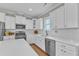 Charming kitchen with white cabinetry, stainless appliances, quartz countertops and decorative tile backsplash at 736 Varina Ln, Fuquay Varina, NC 27526