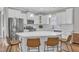 Bright eat-in kitchen featuring white cabinets, stainless steel appliances, quartz counters and pendant lighting at 736 Varina Ln, Fuquay Varina, NC 27526