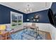 Stylish home office with a large window, modern lighting, and elegant blue accent wall at 736 Varina Ln, Fuquay Varina, NC 27526
