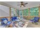 Comfortable screened porch with ceiling fan, blue cushioned furniture, and view of private, wooded backyard at 736 Varina Ln, Fuquay Varina, NC 27526